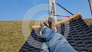 Carefree man relaxing in hammock, spring vacation outside city, tranquility