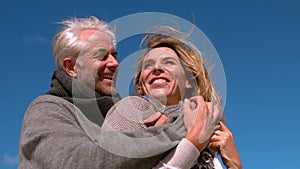 Carefree mature couple hugging on sunny day