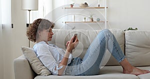 Carefree middle aged beautiful happy woman typing on smartphone.