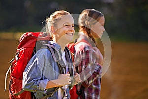 Carefree in nature. Shot of two young girls wearing backpacks walking together.