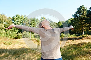 Carefree older woman with arms outstretched