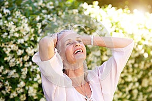 Carefree older woman with hands in hair photo