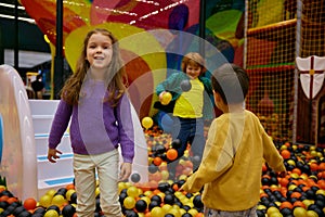 Carefree preschool children playing together on indoor playground