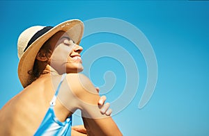 Carefree relaxed woman in hat enjoying summer beach vacation.