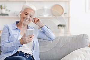 Carefree Retirement. Senior Woman Listening Music On Smartphone With Earphones At Home