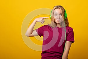 Carefree smiling teen girl listens music in headphones