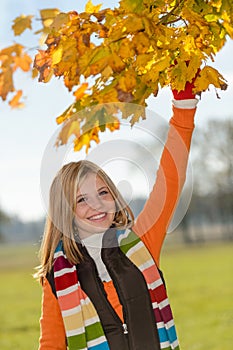 Carefree teen girl picking leaves fall playing