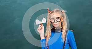 Carefree teenager. Fashionable blonde girl chalkboard background. Back to school. Stylish school pupil modern girl. Cute