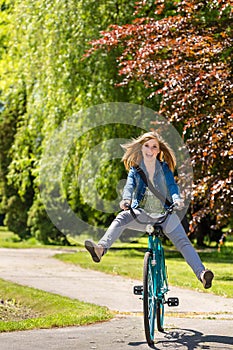 Carefree teenager riding bicycle across the park