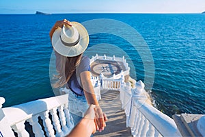 Carefree tourist woman in hat leading her boyfriend to the sea view. Follow me. Balcon del Mediterraneo, Benidorm, Spain photo