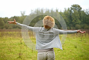 Carefree woman with arms spread open outdoors