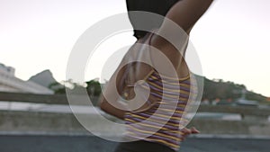 Carefree woman dancing outside in an urban setting at dusk. Beautiful young female fitness instructor preparing a