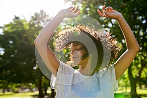 Carefree woman dancing in a park on a sunny afternoon