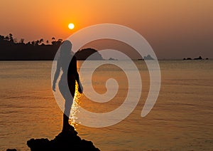 Carefree woman dancing in the sunset on the beach. vacation vitality healthy living concept