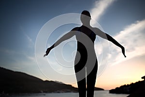 Carefree woman dancing in the sunset on the beach.Vacation vitality healthy living concept