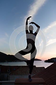 Carefree woman dancing in the sunset on the beach.Vacation vitality healthy living concept