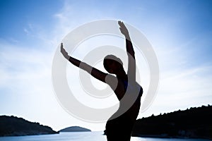 Carefree woman dancing in the sunset on the beach. Vacation vitality healthy living concept