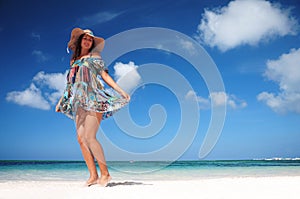 Carefree woman dancing on the tropical beach. vacation vitality