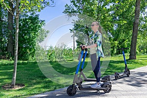 Carefree woman go for drive on rental electric scooter in park.