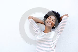 Carefree woman leaning back with hands behind head