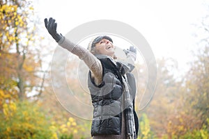 Carefree Woman with Outstreched Arms in Autumn photo