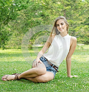 Carefree woman sitting in a green field