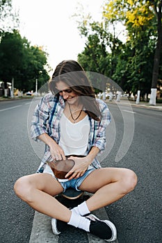 Carefree woman sitting in the middle of an empty city road, hand in fanny pack