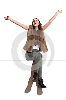 Carefree Woman Sitting On A Top With Arms Outstretched