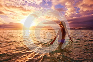 Carefree woman in the sunset on the beach. vacation vitality healthy living concept.