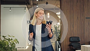 Carefree woman taking break and dancing to music with smartphone in hand