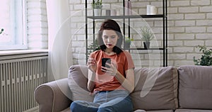 Carefree young european appearance woman using mobile app.