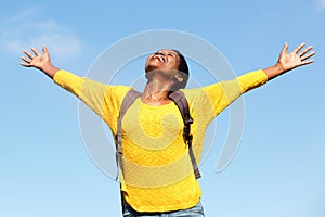 Carefree young woman with arms outstretched outdoors