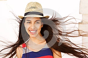 Carefree young woman with long hair blowing in the wind