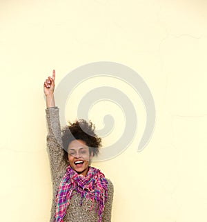 Carefree young woman pointing finger up photo