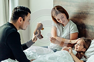 Careful caucasian family taking care of ill daughter
