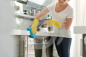 Careful female person using rag at kitchen