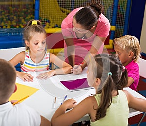 Careful girls and boys drawing pencils on lesson