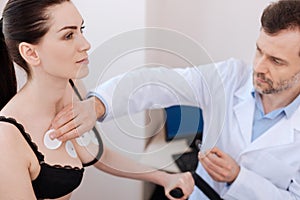 Careful medical worker applying sensors on womans chest