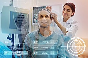 Careful nurse touching the wires while preparing her patient for EEG