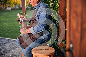 Careful sommelier pouring wine into the decanter outdoors
