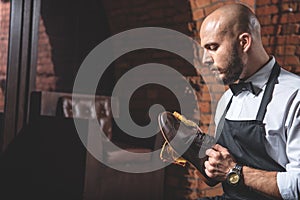 Careful worker cleaning leather shoes