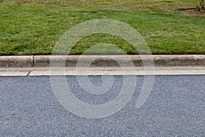 Carefully edged grass alongside extruded concrete curbing and asphalt street, creative copy space options