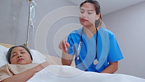 Caregiver care elderly patient while cover blanket on bed at hospital ward, nurse care senior while asleep and support.