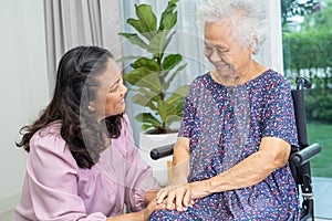 Caregiver help and care Asian senior or elderly old lady woman patient sitting on wheelchair at home