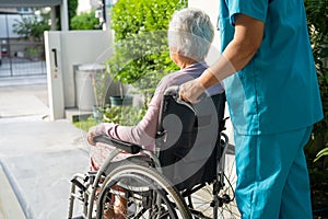 Caregiver help and care Asian senior or elderly old lady woman patient sitting on wheelchair to ramp in nursing hospital, healthy