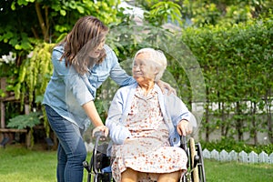 Caregiver help and care Asian senior woman patient sitting on wheelchair at nursing hospital ward, healthy strong medical