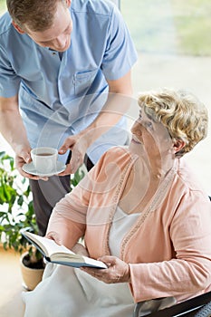 Caregiver helping disabled pensioner