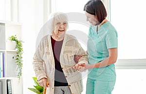 Caregiver helping elderly woman to walk