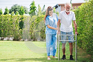 Caregiver helping senior caucasian man to walk