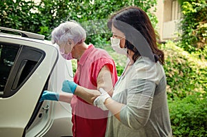 Caregiver helps an elderly client to get into a car to transport for medical appointments.